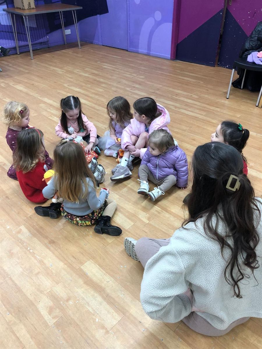 The Mini Geeks teacher sitting in a circle with children during a class activity